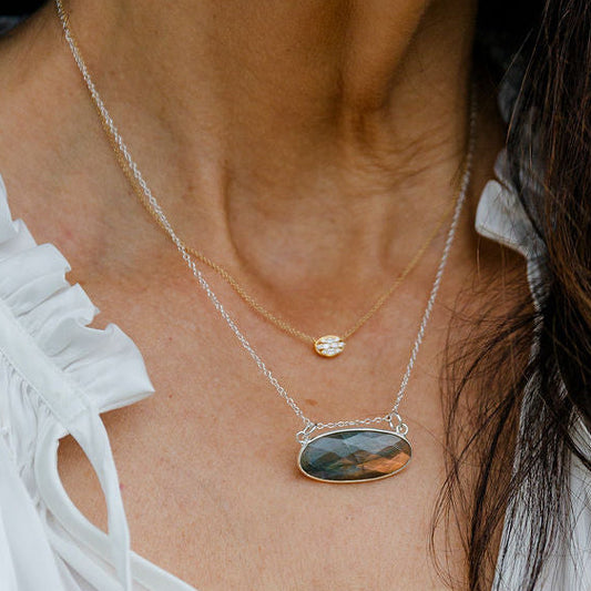Woman wearing a Sterling Silver Labradorite necklace with two yellow roses held in her hands