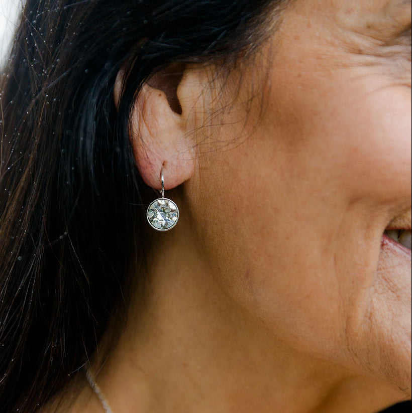 Close-up of a woman wearing sterling silver Sterling Silver Swarovski Crystal Earrings with a blurred background