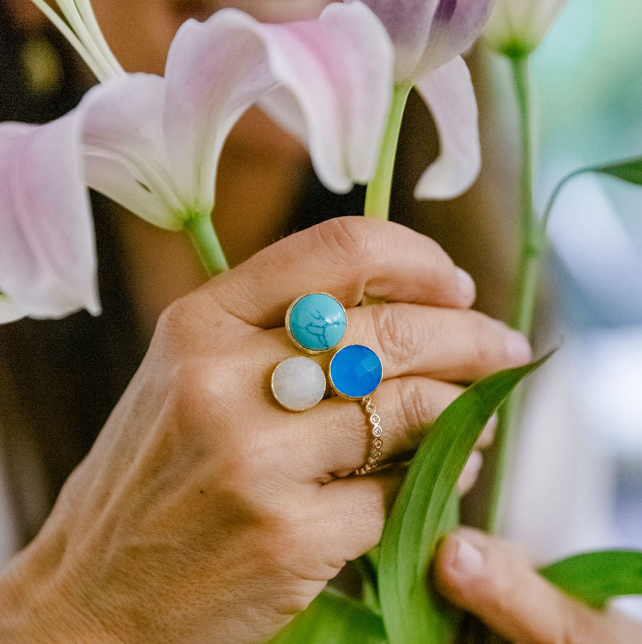 3 Stone Turquoise, Blue Quartz, Moonstone Ring Small 24k gold fill Close-up of hands holding flowers with colorful rings on a blurred background