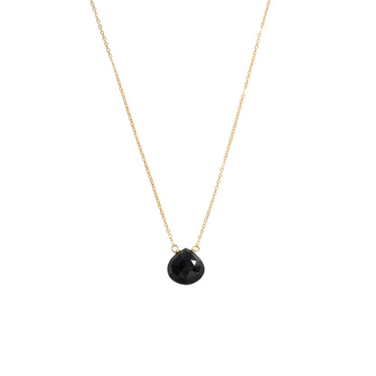 A delicate gold chain necklace featuring a small, faceted black teardrop pendant, shown against a solid white background.