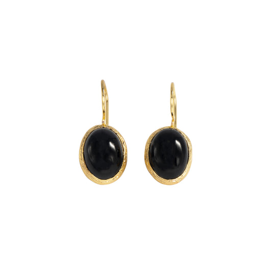 A pair of gold drop earrings with oval black cabochon stones, set against a plain white background.