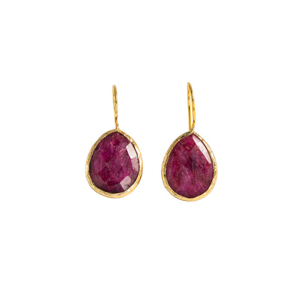 A pair of gold teardrop drop earrings with faceted pinkish-red gemstones, shown on a plain white background.