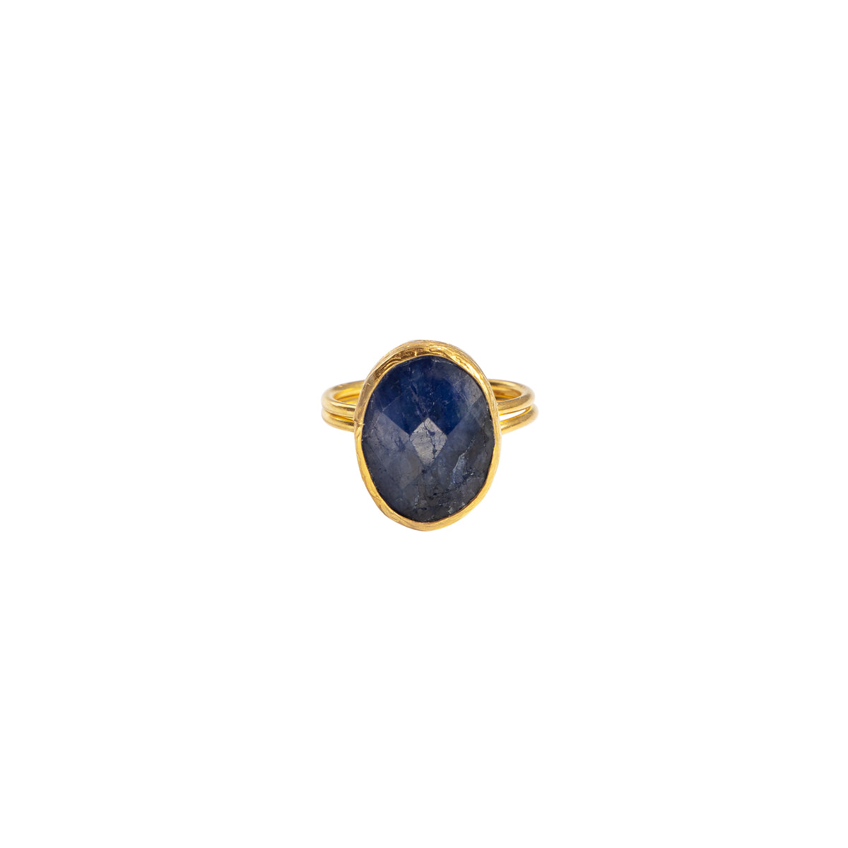 A gold ring featuring an oval-cut dark blue sapphire stone, shown against a plain white background.