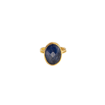 A gold ring featuring an oval-cut dark blue sapphire stone, shown against a plain white background.