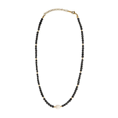 A beaded necklace featuring small black faceted beads separated by tiny gold spacer beads, with a single white pearl accent at the bottom center and a gold chain clasp at the top, shown on a plain white background.